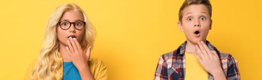 panoramic shot of shocked kids looking at camera on yellow background  clipart