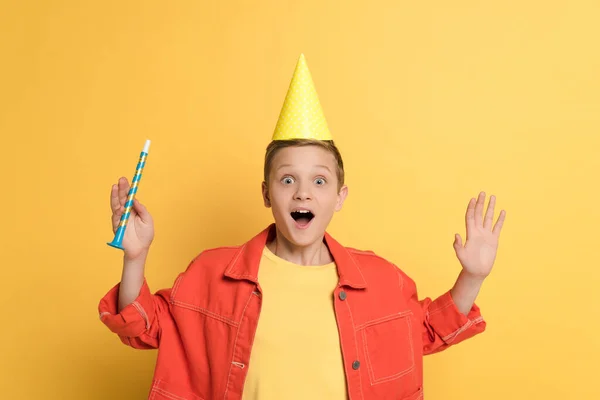 Σοκαρισμένος Παιδί Κόμμα Καπάκι Κρατώντας Κέρατο Κόμμα Στο Κίτρινο Φόντο — Φωτογραφία Αρχείου