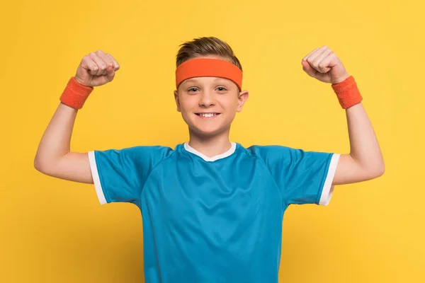 Usmívající Dítě Sportovním Oblečení Ukazuje Silné Gesto Žlutém Pozadí — Stock fotografie