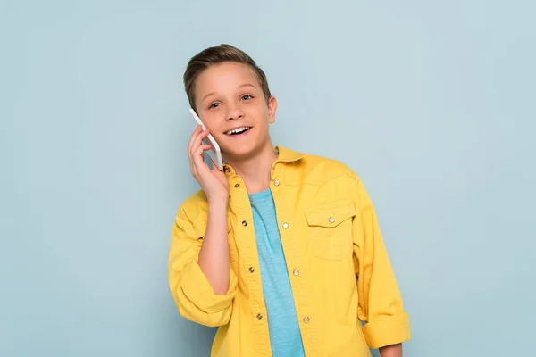 Niño Sonriente Lindo Hablando Teléfono Inteligente Sobre Fondo Azul — Foto de Stock