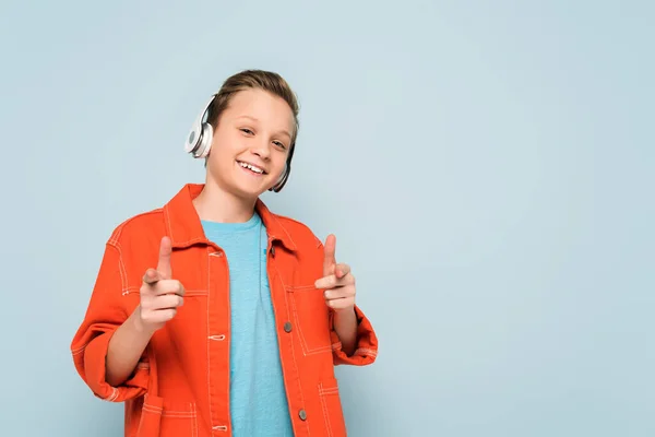 Niño Sonriente Con Auriculares Escuchando Música Señalando Con Los Dedos —  Fotos de Stock