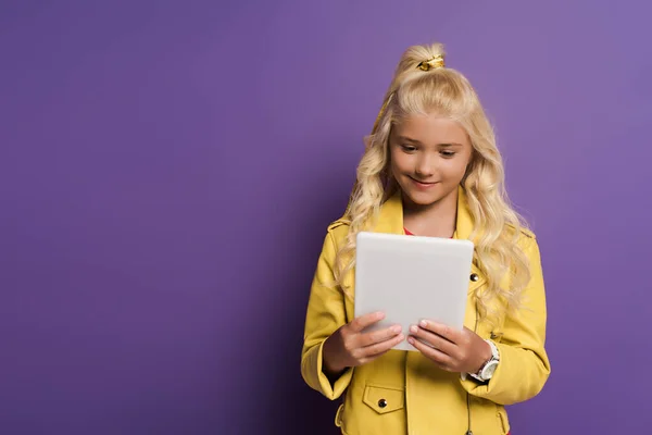 笑着的孩子用紫色背景的数码平板电脑与复制空间 — 图库照片