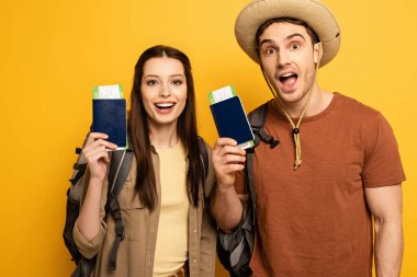 Sırt çantalı birkaç heyecanlı gezgin ellerinde pasaportlar ve sarı biletler var.