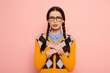 attractive sad female nerd in eyeglasses, Isolated on pink clipart