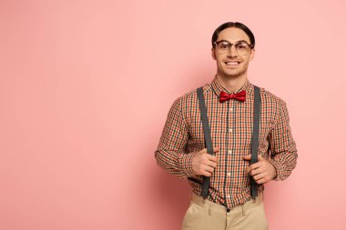 smiling male nerd in eyeglasses and suspenders on pink clipart