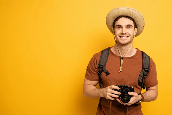 Cheerful Traveler Hat Backpack Holding Photo Camera Yellow — Stock Photo, Image