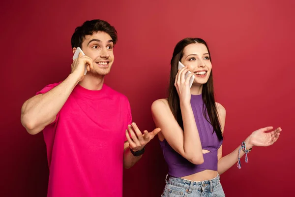 Schönes Emotionales Paar Das Auf Smartphones Auf Rot Spricht — Stockfoto