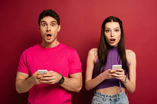 Hermosa Pareja Sorprendida Usando Teléfonos Inteligentes Rojo — Foto de Stock