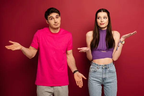 Confused Young Couple Shrug Gestures Red — Stock Photo, Image