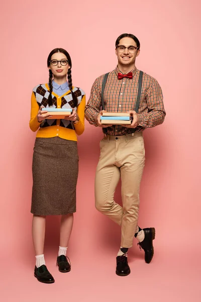 ピンクの本を持っている眼鏡の明るい神経のカップル — ストック写真