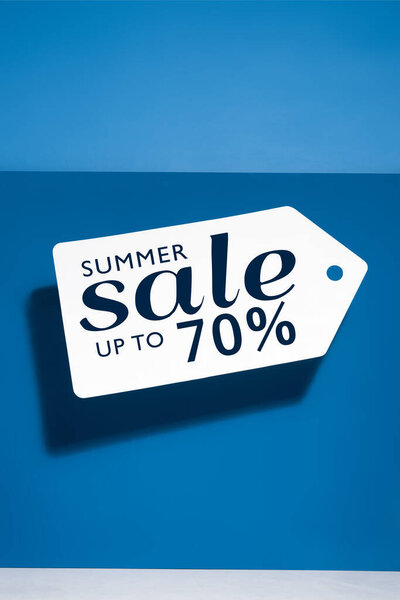 белый большой ценник с иллюстрацией летней распродажи на синем фоне

