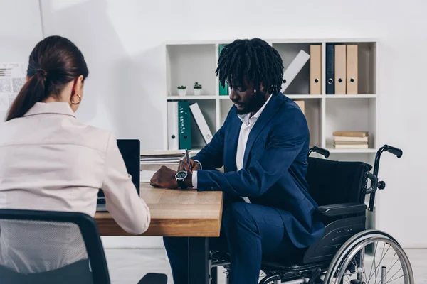 Africano Americano Deficiente Empregado Escrevendo Perto Recrutador Trabalhando Com Laptop — Fotografia de Stock