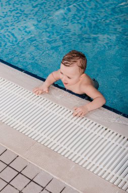 Yüzme havuzunda küçük şirin bir çocuğun manzarası. 