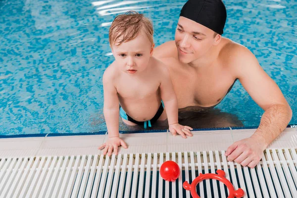 Pelatih Renang Tampan Dengan Topi Renang Melihat Anak Balita Kolam — Stok Foto