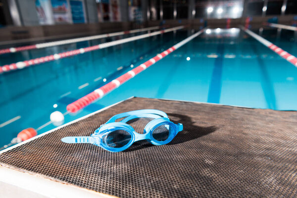 goggles near swimming pool with blue water 