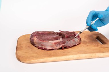 Cropped view of doctor with syringe doing hormonal injection in raw meat on cutting board isolated on white clipart