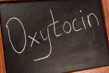 Close up view of lettering oxytocin on blackboard with wooden frame clipart
