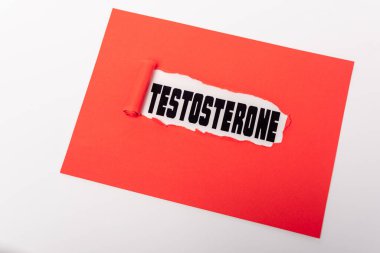 Beyazda izole edilmiş kırmızı kağıt deliğinde testosteron harfleri.