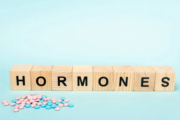 Piller Och Träkuber Med Hormoner Bokstäver Blå Yta — Stockfoto