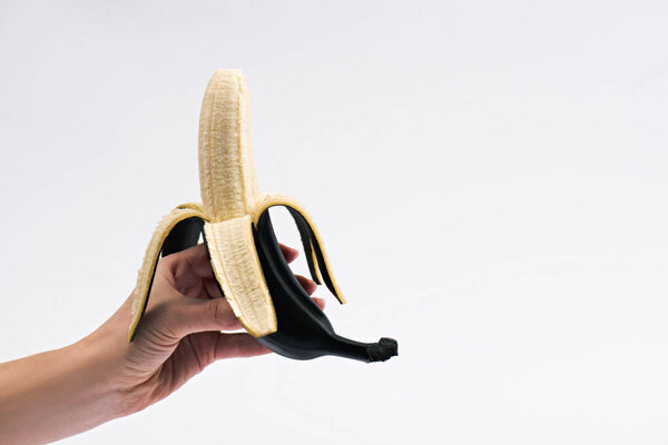 cropped view of woman holding peeled banana isolated on white