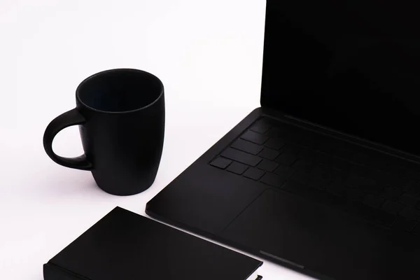 Notizbuch Und Tasse Neben Schwarzem Laptop Auf Weißem — Stockfoto