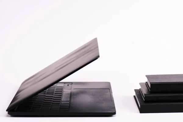 Σημειωματάρια Κοντά Στο Μαύρο Και Σύγχρονο Φορητό Υπολογιστή Λευκό — Φωτογραφία Αρχείου
