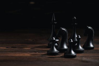 Siyah üzerine izole edilmiş tahta yüzeydeki satranç figürleri 