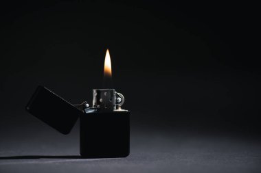 lighter with burning fire on black with copy space  clipart