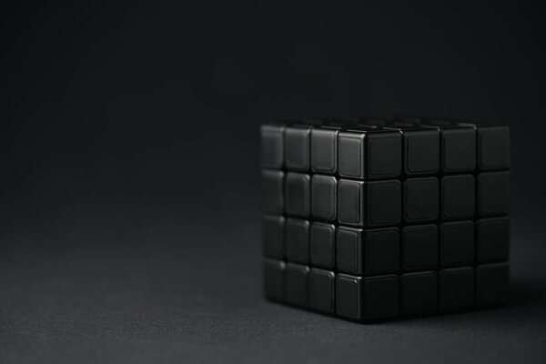 KYIV, UKRAINE - FEBRUARY 21, 2020: selective focus of dark rubik cube on black with copy space 