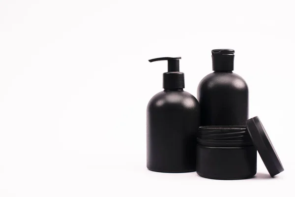 Recipiente Negro Con Crema Facial Cerca Botellas Aisladas Blanco — Foto de Stock