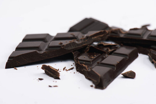 selective focus of cracked and sweet chocolate on white 