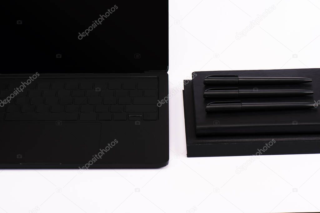 pens and notebooks near modern laptop with blank screen isolated on white 