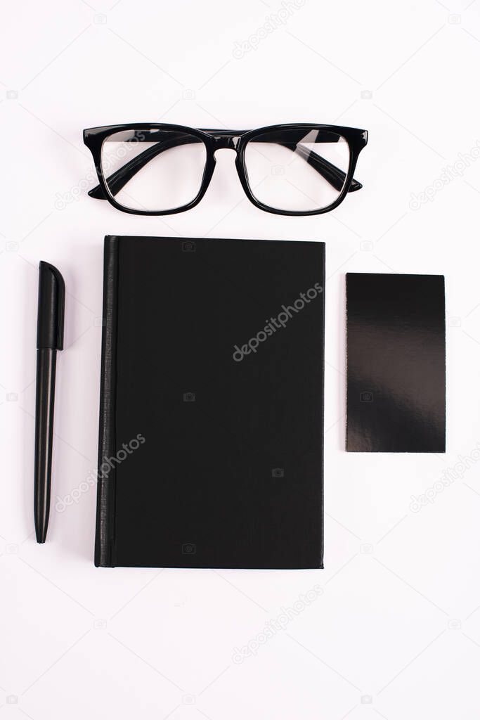 top view of glasses, notebook, pen and blank card isolated on white 