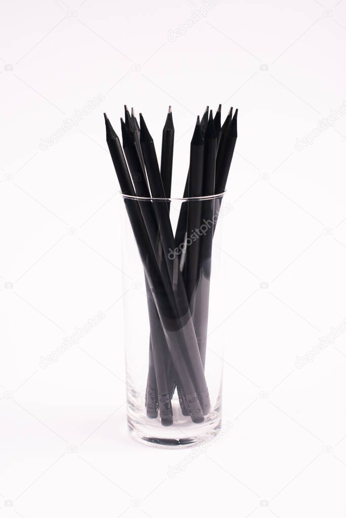 black and wooden pencils in glass isolated on white 