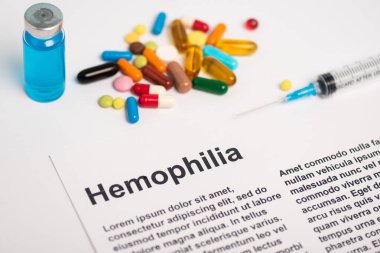 Paper with hemophilia lettering near syringe, vaccine and pills on white background clipart