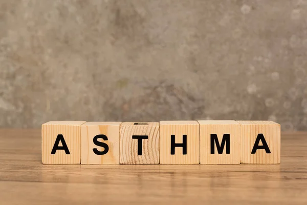 Cubos Madera Con Letras Asma Mesa Madera Sobre Fondo Gris — Foto de Stock