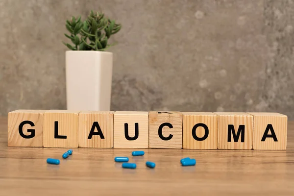 Selektivní Zaměření Glaukomu Nápisy Kostky Pilulky Rostliny Dřevěném Stole Šedém — Stock fotografie