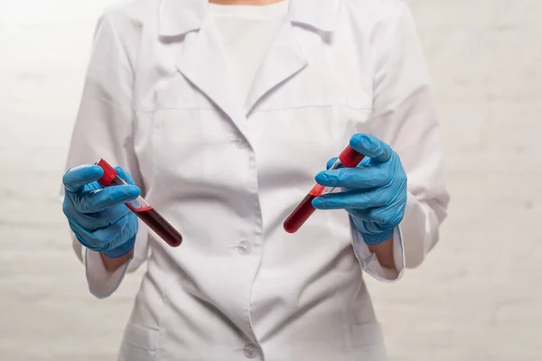Ausgeschnittene Ansicht Des Arztes Der Reagenzgläser Mit Blutproben Auf Weißem — Stockfoto
