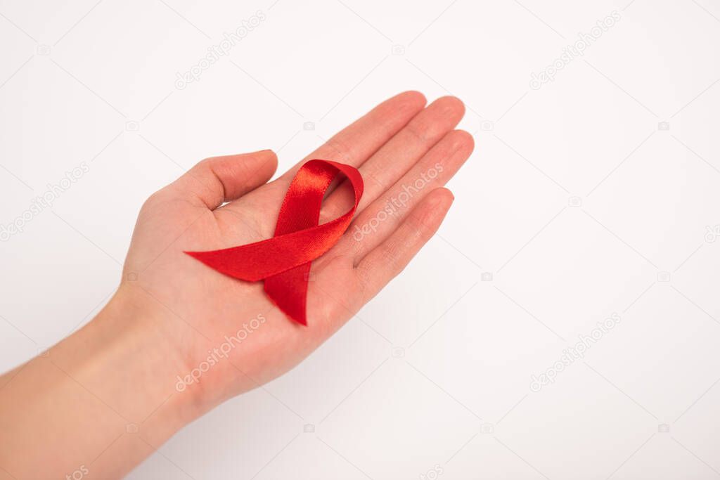 Cropped view of woman holding aids awareness red ribbon isolated on white