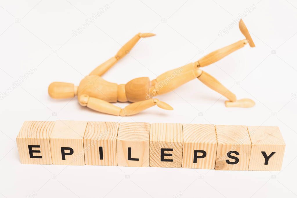 Selective focus of cubes with epilepsy lettering and wooden toy on white background
