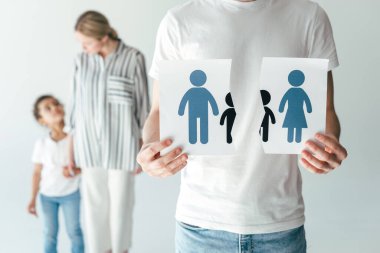 man holding ripped paper with drawn family near woman and adopted african american kid on white   clipart