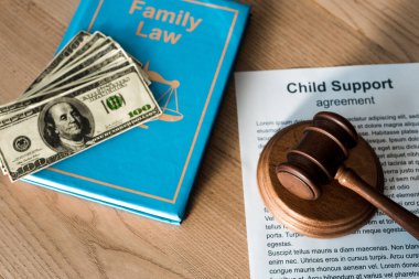 wooden gavel near document with child support agreement, dollar banknotes and family law  clipart