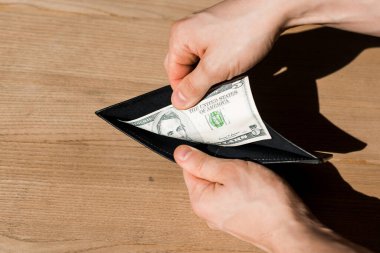 Bir dolar banknotla cüzdan tutan adam manzarası. 