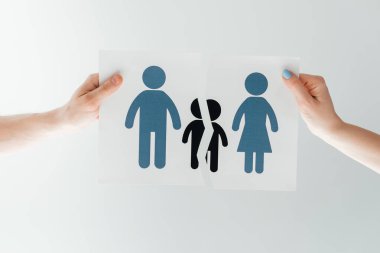 cropped view of man and woman holding ripped paper with separated family on white  clipart