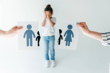 Seçici odak noktası, ellerinde yırtık kağıtlar olan beyaz ırk üzerinde evlat edinilmiş Afrikalı Amerikalı kızın yanında boşanmış bir aile. 