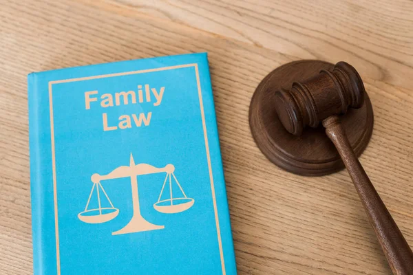 机の上に家族法の文字が書かれた本の近くの木製の砂利 — ストック写真
