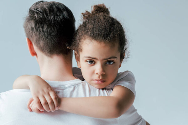 back view of foster father taking away upset african american daughter isolated on white, custody concept 