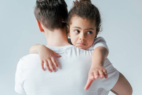back view of foster father taking away sad african american daughter isolated on white, custody concept 