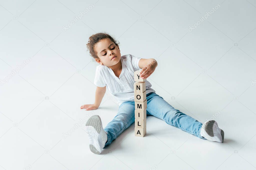 cute african american kid near wooden cubes with alimony lettering on white 