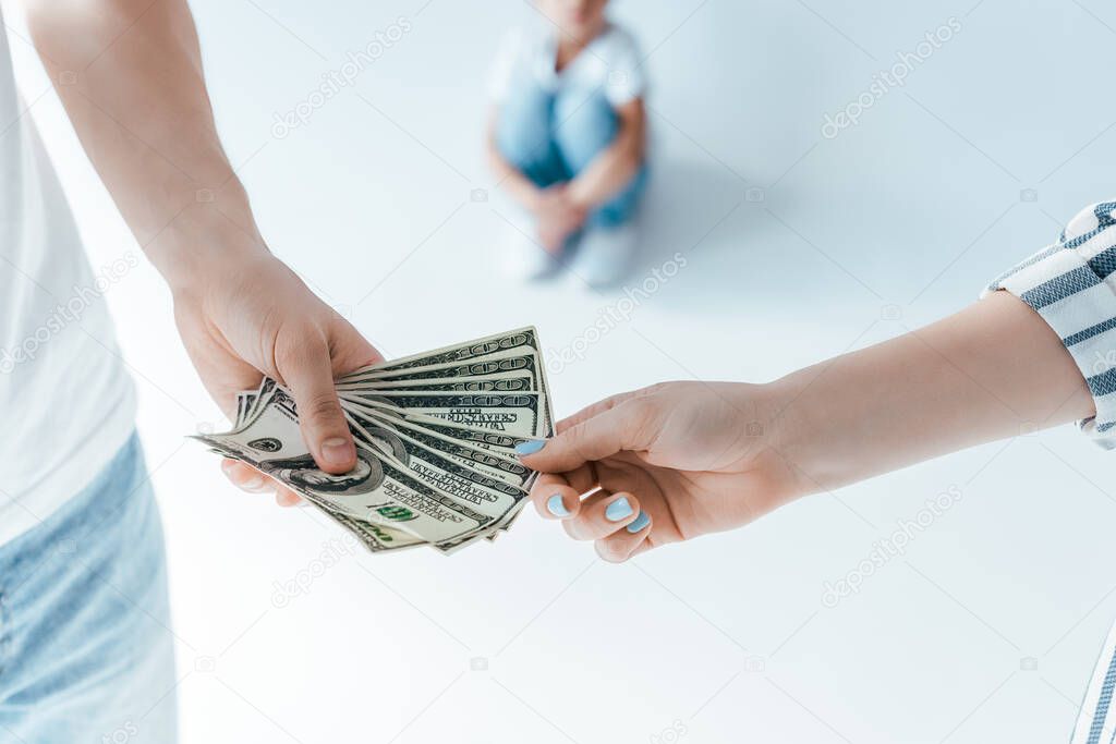 selective focus of man giving alimony to woman near kid on white